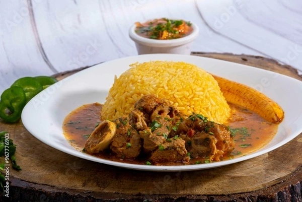 Fototapeta A mouthwatering dish of Seco de chivo chancho featuring a rich and savory sauce, served with tender chunks of goat, pork, and beef. Accompanied by a generous portion of moros de lenteja (lentil rice)