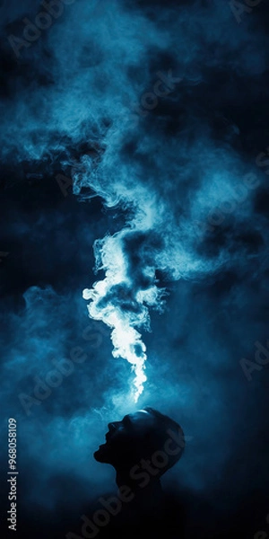 Fototapeta A silhouette of a person with blue smoke rising from the head, conveying a sense of creativity and inspiration in a mystical atmosphere.