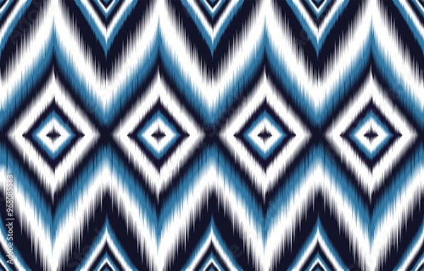 Fototapeta Blue and white ikat pattern. Seamless chevron design with diamond motifs. Trendy ethnic print for fashion and interiors. Abstract geometric background. Bohemian style textile. Aztec-inspired artwork.