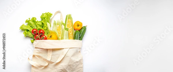 Fototapeta Vegetarian grocery shopping. Different fresh vegetables in a textile shopper bag on white background, healthy vegan food from supermarket or delivery concept, space for text.