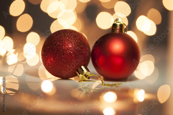 Obraz  Two red christmas balls with blurred light background