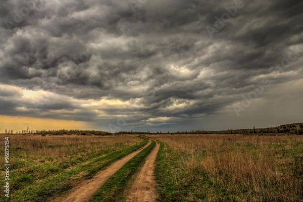 Fototapeta dirt road going into the eye of the storm.