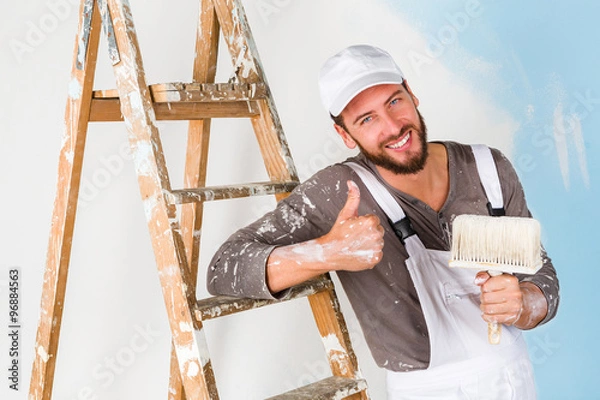 Fototapeta painter in white dungarees with thumbs up gesture