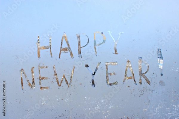 Fototapeta happy new year written on frosty winter window background