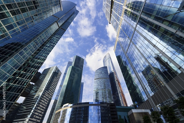 Obraz Współczesne wieżowce biurowe, patrząc na wieżowce w dzielnicy komercyjnej, architektura podnosząca na niebieskie niebo z białymi chmurami, widok na dole