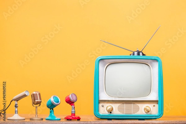 Obraz Retro TV and old microphones front yellow wall background. Vintage style filtered photo