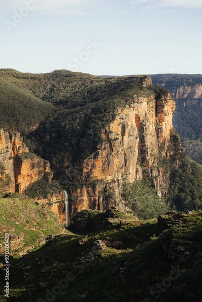 Fototapeta Waterfall in a mountain range surrounded by forest