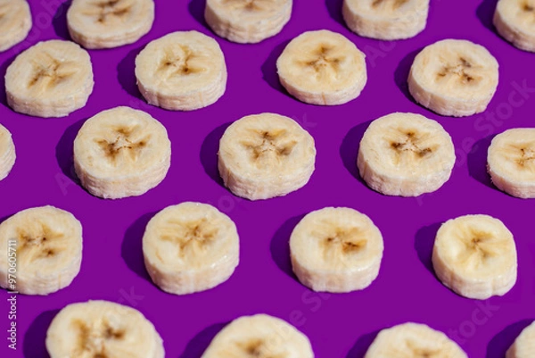 Fototapeta Banana slices on a purple surface