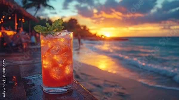 Fototapeta A vibrant cocktail sits on wooden table, reflecting warm hues of stunning sunset at beachside bar. scene captures relaxed atmosphere, perfect for gatherings
