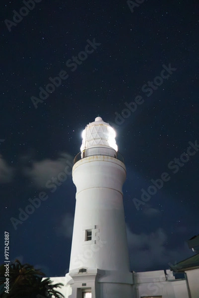 Obraz 星空広が広がる夜と灯台の光