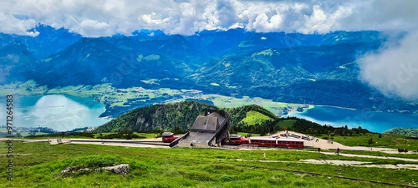 Fototapeta A stunning view from the Schafberg in Austria, showcasing the Schafberg Railway station with expansive vistas of the surrounding lakes and mountains. The Schafberg is a popular destination for hikers 