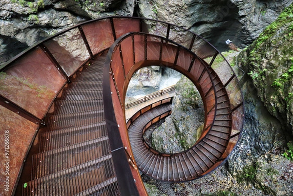 Fototapeta A unique spiral metal staircase carved into the rocky cliffs of Austria's Sigmund-Thun Gorge, offering adventurous visitors a stunning pathway through the natural beauty of the gorge