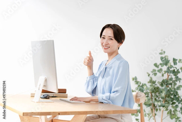 Fototapeta パソコンの前でサムズアップをする女性