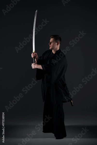 Fototapeta Samurai ninja warrior in kimono in attack pose with katana sword. dark room. sword shine. fighter. japanese culture