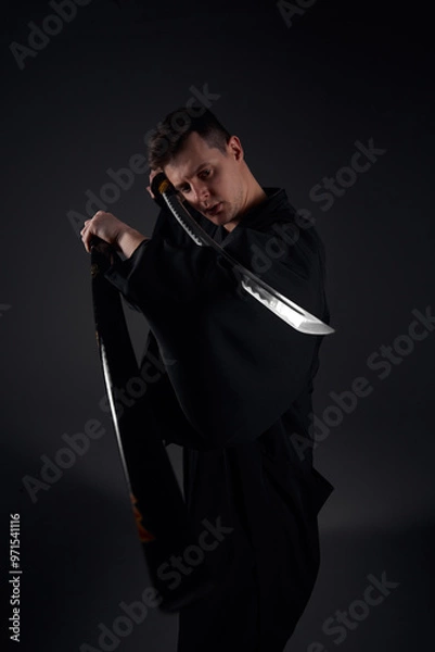 Fototapeta Samurai ninja warrior in kimono in attack pose with katana sword. dark room. sword shine. fighter. japanese culture