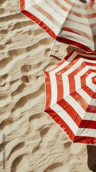 Fototapeta Closeup of beach umbrellas with bright stripes, standing tall on the sand..