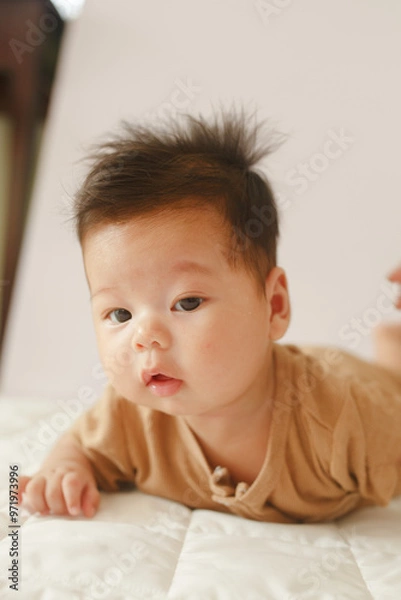 Obraz a baby laying on top of a bed