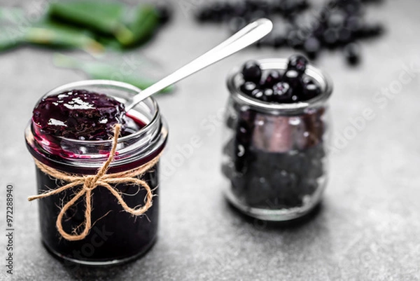 Obraz Aronia jam and fresh berry on stone table.