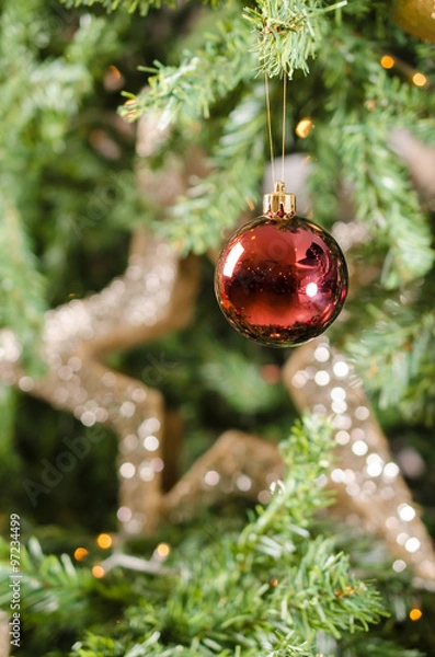 Obraz Red Christmas ornament with blury shining star in the background