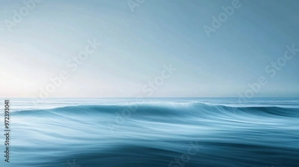 Fototapeta A minimalist image of ocean waves rolling softly toward the shore, with a wide-open horizon in the distance