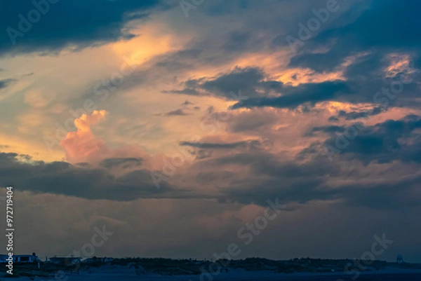 Fototapeta Avalon, New Jersey, USA - The view from the ocean looking at the homes on the coastline with dramatic clouds above them in this beach town on the southern New Jersey