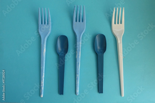Fototapeta Blue and white fork and spoon on blue background - party time concept