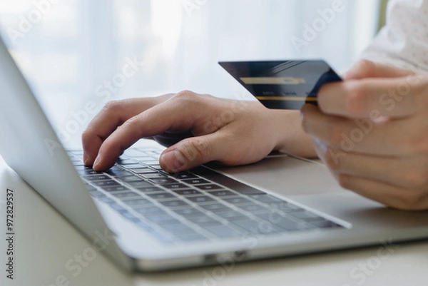 Fototapeta Man using credit card and laptop computer for online payment. Businessman or entrepreneur working from home. Online shopping, e-commerce, and internet banking concept.