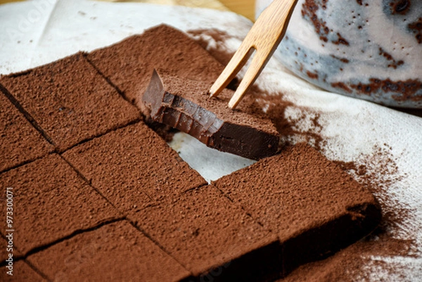 Fototapeta Japanese Nama Chocolate is a type of ganache, which is made from a mix of melted cacao and fresh cream. The block of chocolate cut into pieces and sprinkled with cocoa powder.