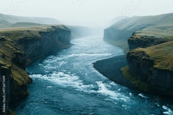 Obraz A River Flowing Through a Foggy Canyon in Iceland