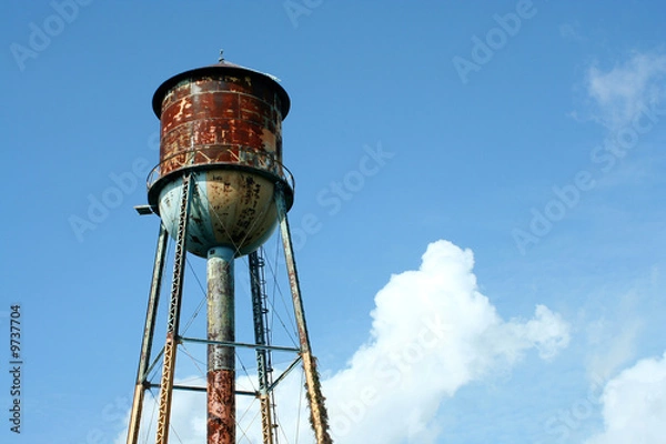 Obraz A Old rusty watertower against blue sky