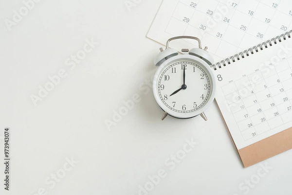 Fototapeta close up of calendar and alarm clock on the white table background, planning for business meeting or travel planning concept
