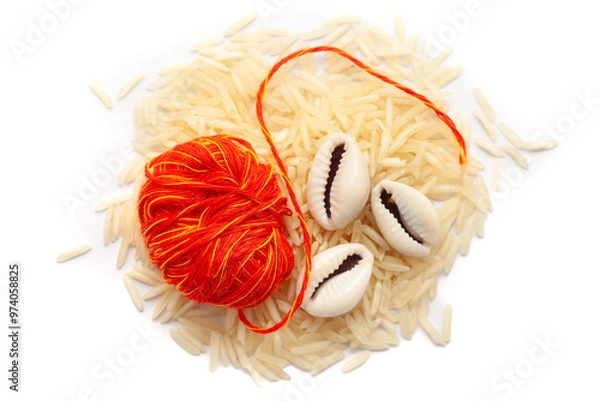 Obraz A pile of rice with kalawa (pooja thread) and Cowrie (Cypraea chinensis). Isolated on a white background.