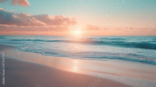 Fototapeta A serene beach at sunset, with soft waves lapping at the shore and a colorful sky reflecting the tranquil transition of day to night.