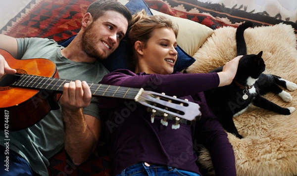 Fototapeta Couple, pet and guitar in apartment for love, bonding and music together on floor with blanket or pillow. Man, woman and playing instrument in house for romance, relationship and cat with support