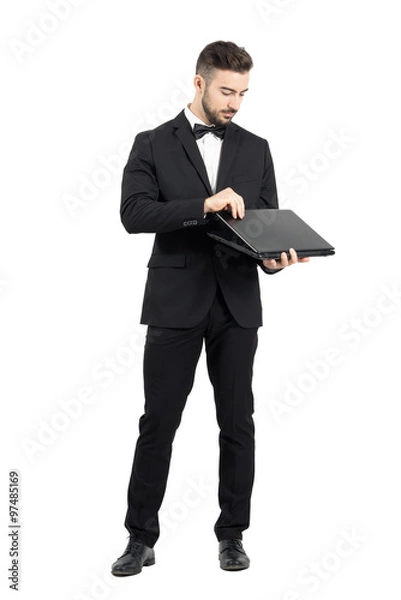 Fototapeta Young businessman opening laptop. Full body length portrait isolated over white studio background. 