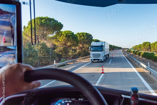 Fototapeta View from inside a truck on a highway with cones separating the two lanes for two-way traffic, transfer.