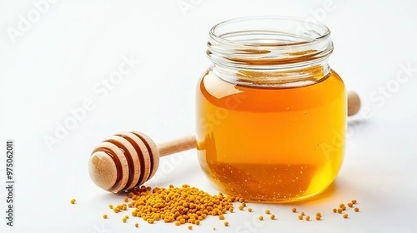 Fototapeta   A jar of honey next to a wooden honey dipper on a white background