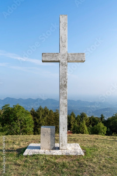 Obraz Cruise on top of a hill overlooking the village of Alano di Piave in the background on a beautiful
