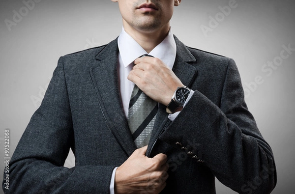 Fototapeta man in a tuxedo tie tightens