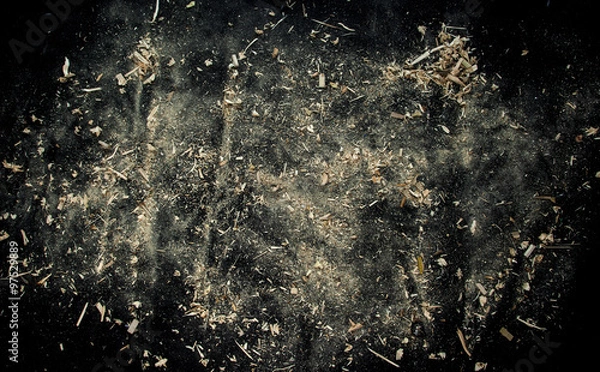 Obraz Explosion of sawdust on black background.
