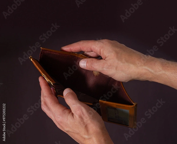 Fototapeta Male hands hold open an old empty wallet