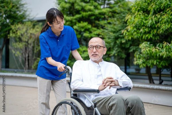 Obraz 車いすのシニア男性と介護施設スタッフ