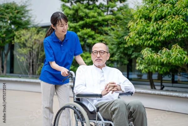 Obraz 車いすのシニア男性と介護施設スタッフ