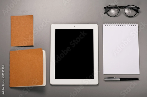 Fototapeta Tablet computer with a notebook, glasses and pen