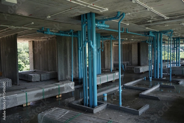 Fototapeta A large building currently under construction that has many blue pipes