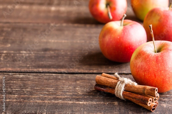 Fototapeta fresh apples and cinnamon on a wooden table