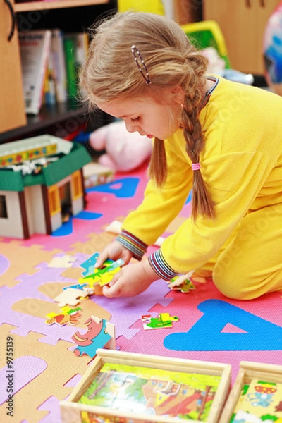 Fototapeta Cute child playing with puzzle