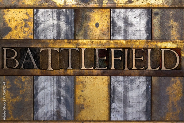 Fototapeta Battlefield text in real authentic typeset letters on vintage textured silver grunge copper and gold background