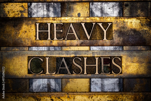 Fototapeta Heavy Clashes text in real authentic typeset letters on vintage textured silver grunge copper and gold background