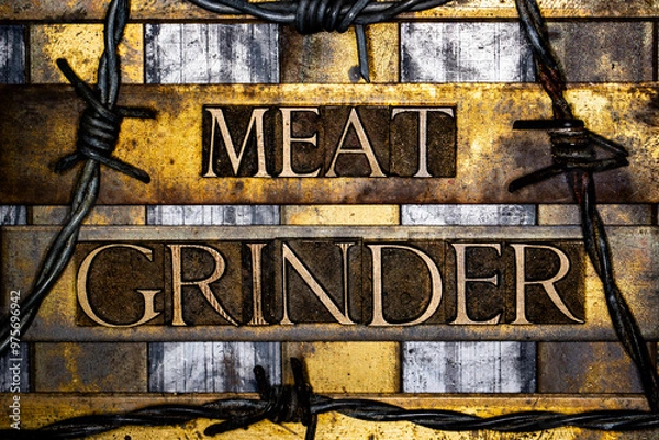 Fototapeta Meat Grinder text with barbed wire in real authentic typeset letters on vintage textured silver grunge copper and gold background